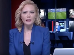 Tijen Karas reading a military statement on Turkish TV while being held at gunpoint.