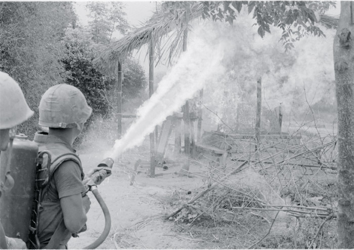 A US Marine torches a Vietnamese home with a flamethrower.