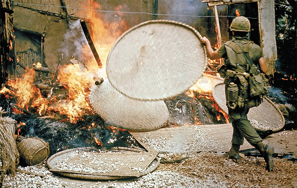 American soldier stoking burning houses during the My Lai massacre, March 16, 1968, My Lai, South Vietnam. Ronald L. Haeberle.