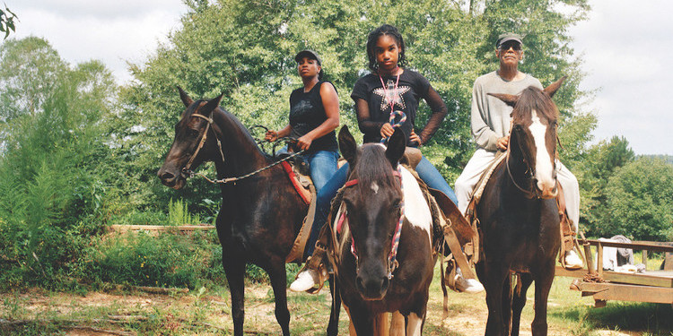 *LaToya Ruby Frazier, _Zion, Her Mother Shea, and Her Grandfather Mr. Smiley Riding on Their Tennessee Walking Horses, Mares, P.T. (P.T.’s Miss One Of A Kind), Dolly (Secretly), and Blue (Blue’s Royal Threat), Newton, Mississippi, 2017/19_, 2021,* ink-jet